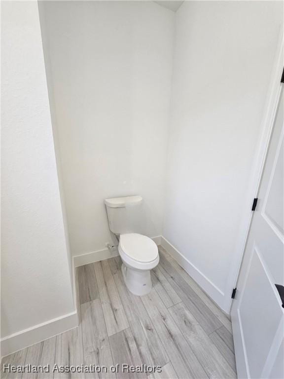 bathroom featuring hardwood / wood-style floors and toilet