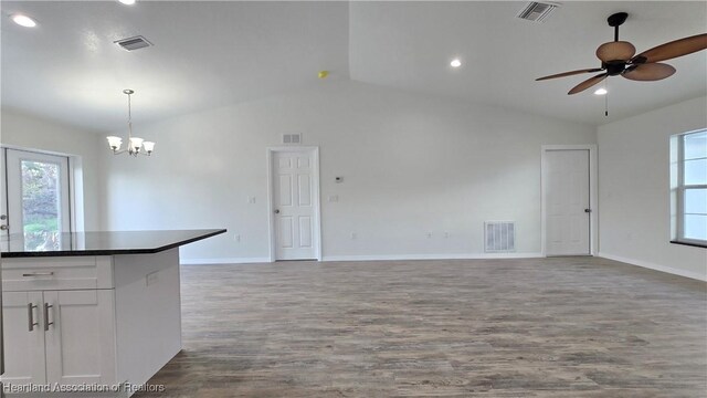 interior space featuring ceiling fan with notable chandelier, wood-type flooring, and vaulted ceiling