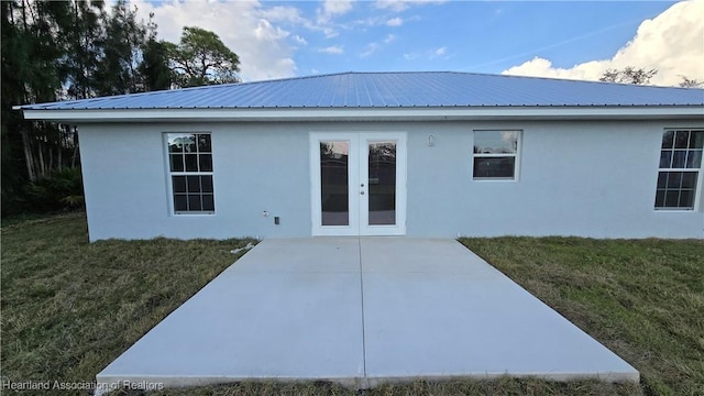 back of house featuring a patio, a lawn, and french doors