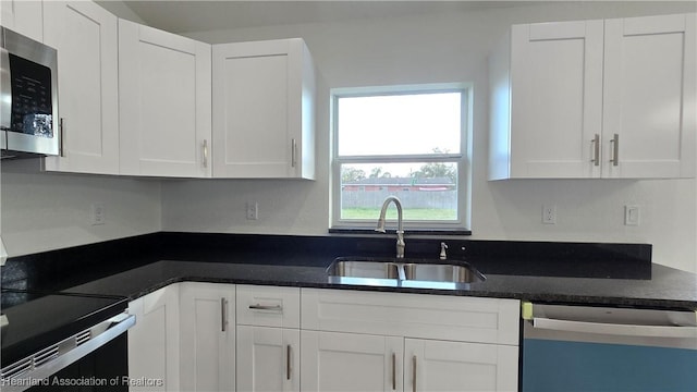 kitchen with stainless steel appliances, white cabinetry, and sink