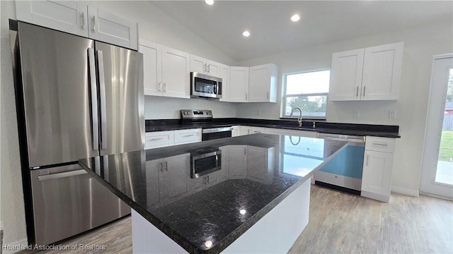 kitchen with a kitchen island, appliances with stainless steel finishes, sink, and white cabinets