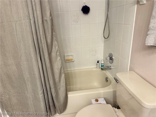 bathroom with shower / tub combo with curtain and toilet