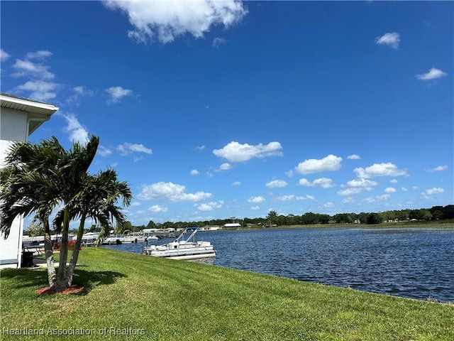 view of dock featuring a water view and a yard