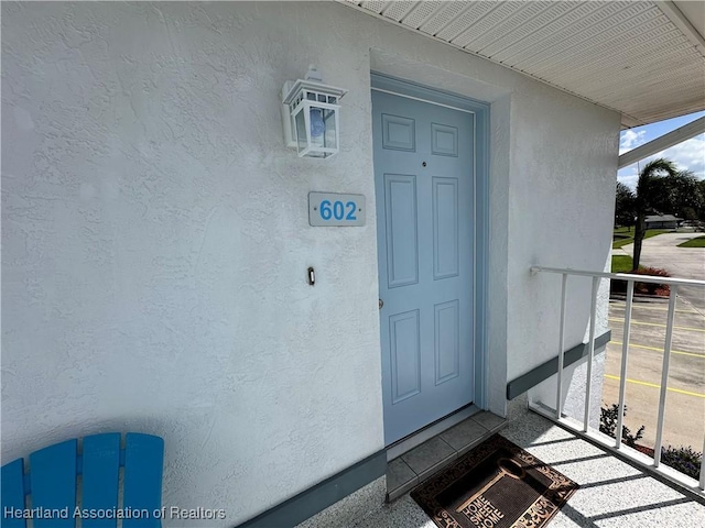 doorway to property featuring stucco siding