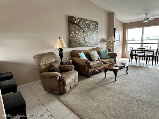 living room with light tile patterned floors, ceiling fan, baseboards, and lofted ceiling