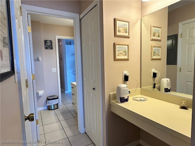 bathroom featuring baseboards, tile patterned flooring, and electric panel