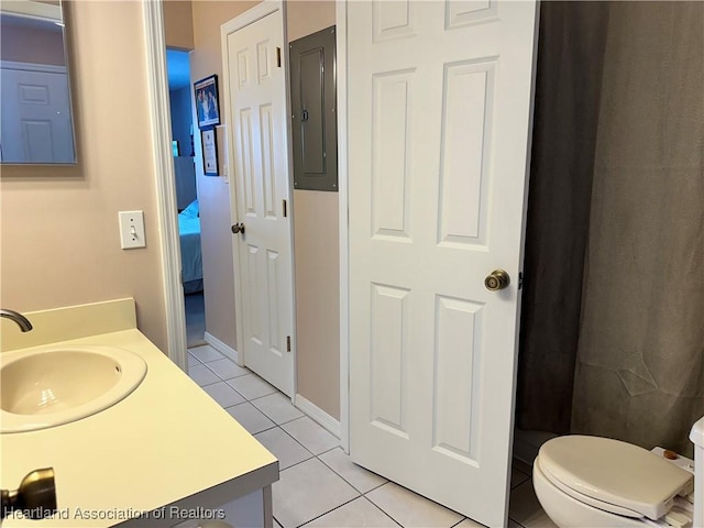 bathroom with toilet, tile patterned floors, vanity, and electric panel
