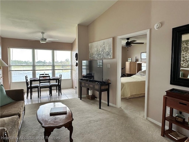 carpeted living area with ceiling fan, vaulted ceiling, and baseboards