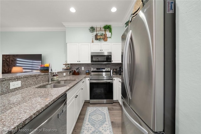 kitchen with decorative backsplash, light stone countertops, stainless steel appliances, and ornamental molding