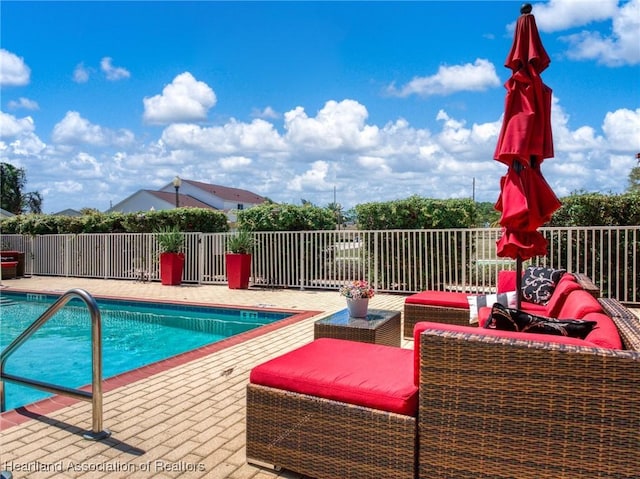 view of pool with an outdoor living space, a fenced in pool, a patio area, and fence