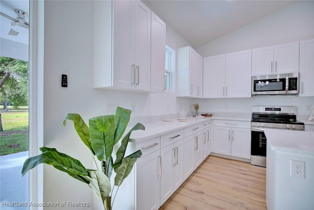 kitchen featuring white cabinetry, light countertops, stainless steel appliances, and vaulted ceiling