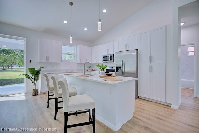 kitchen featuring light countertops, white cabinets, stainless steel appliances, and a healthy amount of sunlight