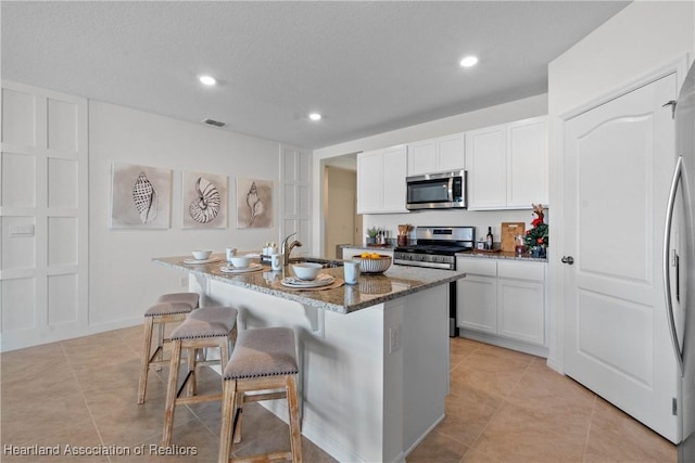 6856 Coconut Dr, Sebring, FL 33872 - kitchen featuring appliances with stainless steel finishes, a sink, dark stone countertops, light tile patterned flooring, and recessed lighting