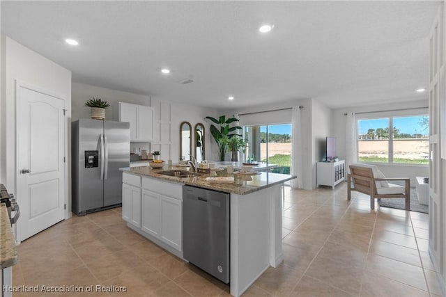 6856 Coconut Dr, Sebring, FL 33872 - kitchen with appliances with stainless steel finishes, recessed lighting, light stone counters, white cabinets, and a center island with sink
