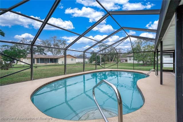 view of pool with a lawn, glass enclosure, and a patio area