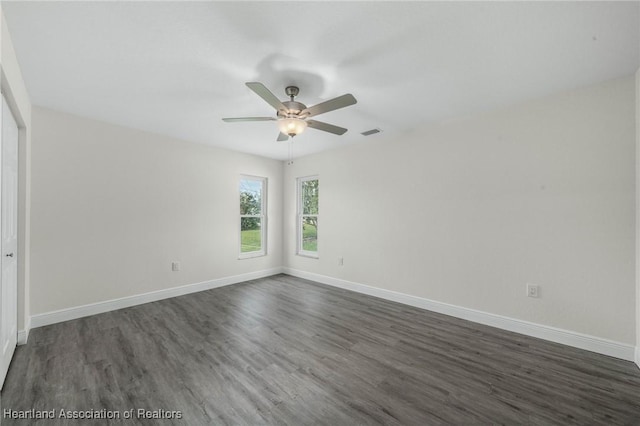 unfurnished room featuring dark wood-type flooring and ceiling fan