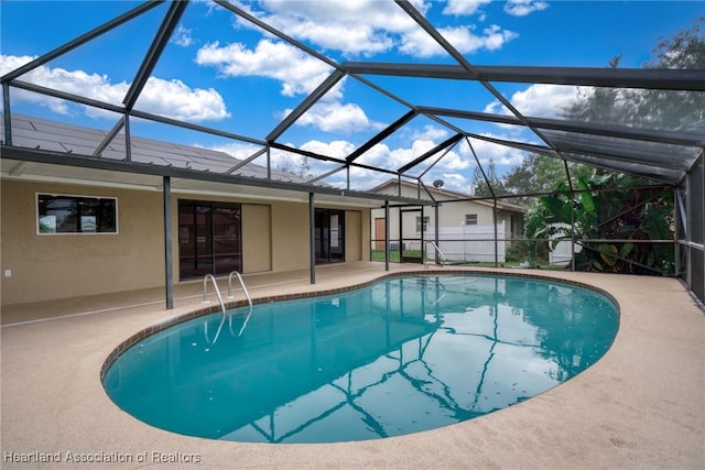 view of swimming pool with a lanai and a patio area