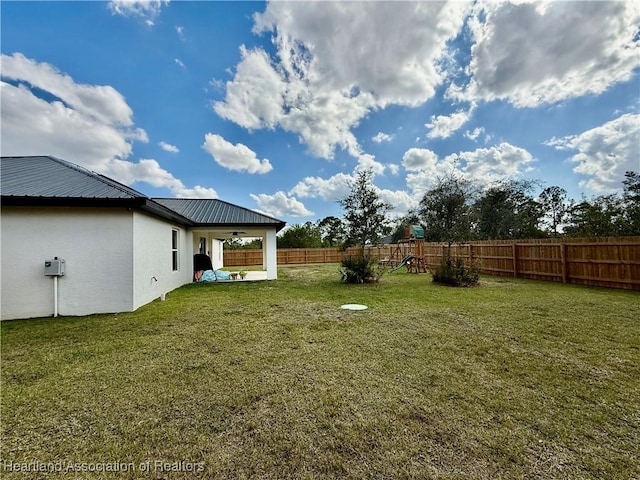 view of yard with a fenced backyard and a playground