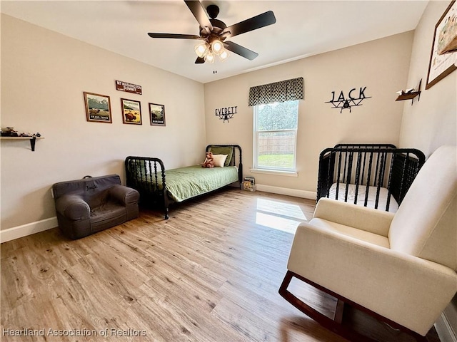 bedroom featuring ceiling fan, light wood finished floors, and baseboards