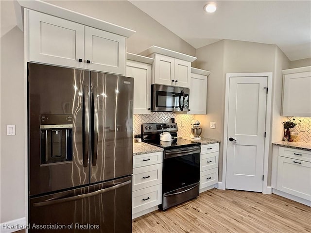 kitchen featuring stainless steel appliances, light wood-style flooring, white cabinetry, and light stone countertops