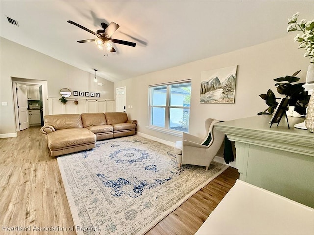 living area with lofted ceiling, light wood finished floors, visible vents, and a ceiling fan