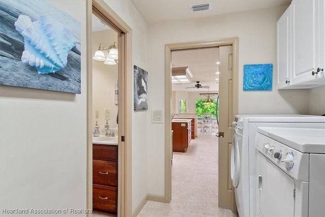 laundry area featuring visible vents, washer and dryer, cabinet space, a ceiling fan, and a sink