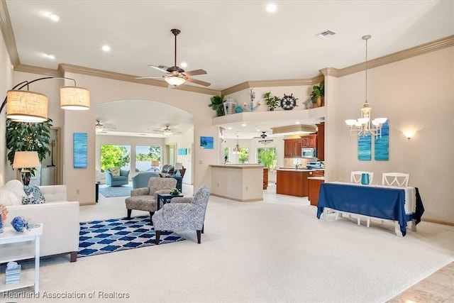 living room featuring crown molding, ceiling fan with notable chandelier, visible vents, and light carpet