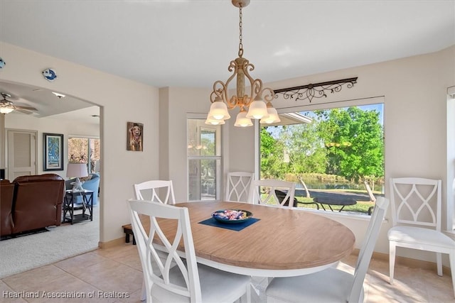 dining area with light tile patterned floors, baseboards, and an inviting chandelier