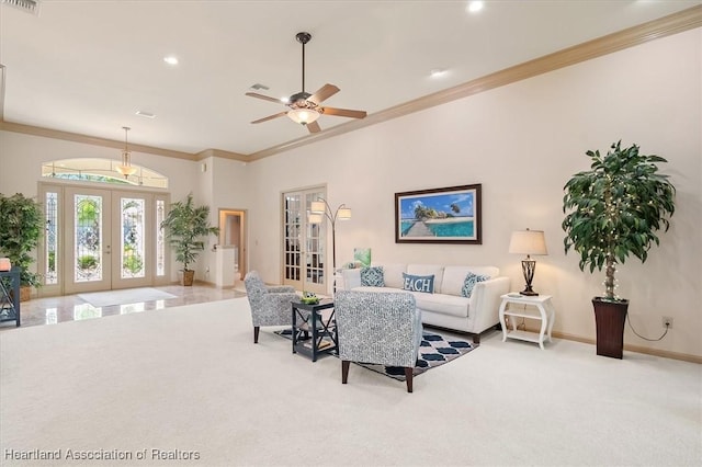 carpeted living area with crown molding, french doors, baseboards, and ceiling fan