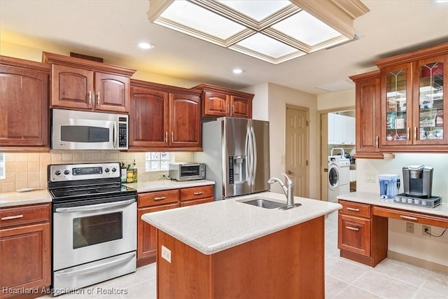 kitchen with a sink, stainless steel appliances, washer / dryer, and light countertops