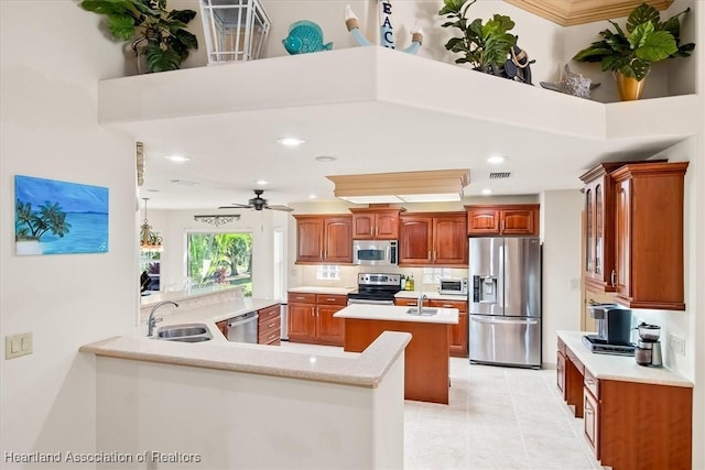 kitchen featuring a sink, appliances with stainless steel finishes, a ceiling fan, and light countertops