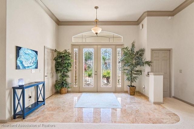 foyer entrance with a towering ceiling, french doors, baseboards, and ornamental molding