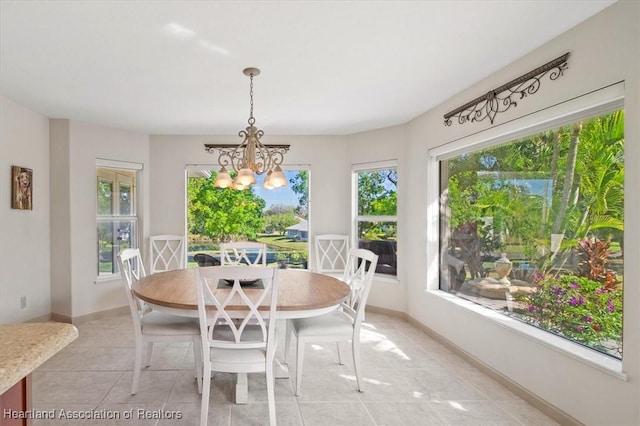 dining room with light tile patterned floors, baseboards, and an inviting chandelier