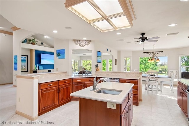 kitchen featuring a sink, an island with sink, and light countertops