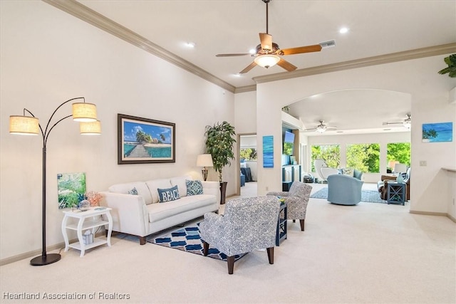 living area featuring carpet, a ceiling fan, visible vents, baseboards, and ornamental molding