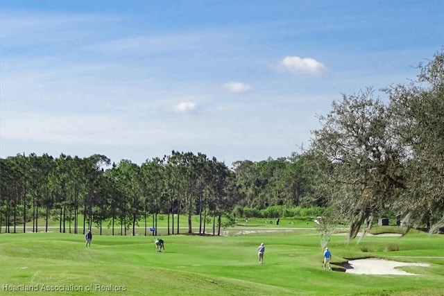 view of home's community with a lawn and golf course view