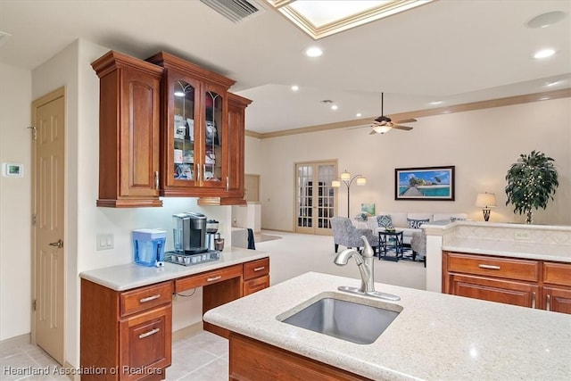 kitchen featuring visible vents, open floor plan, recessed lighting, brown cabinets, and a sink