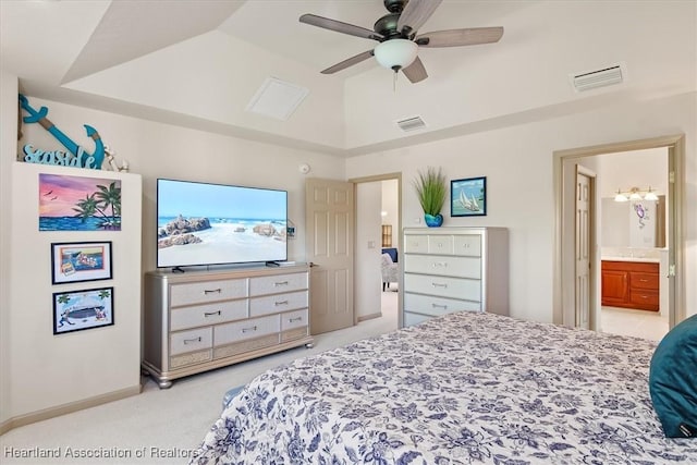 bedroom featuring lofted ceiling, connected bathroom, visible vents, and light carpet