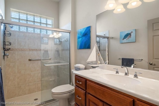 full bathroom with vanity, a shower stall, and toilet