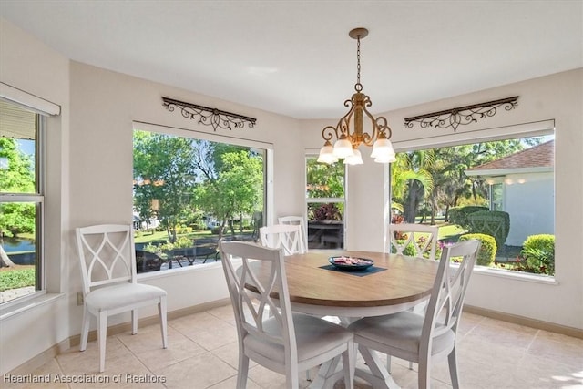 dining area with a notable chandelier, a healthy amount of sunlight, and baseboards