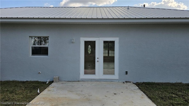 property entrance featuring a patio and french doors