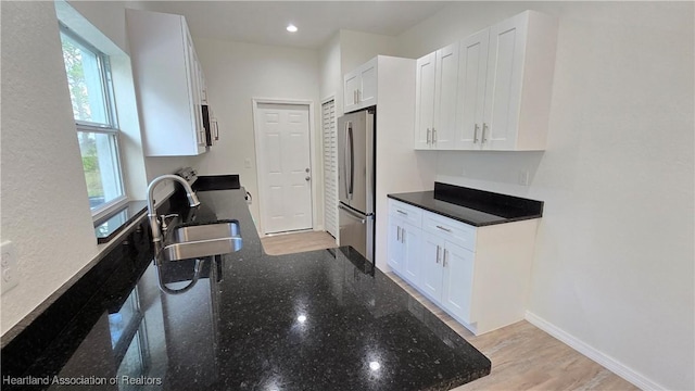 kitchen with white cabinetry, sink, dark stone counters, and appliances with stainless steel finishes