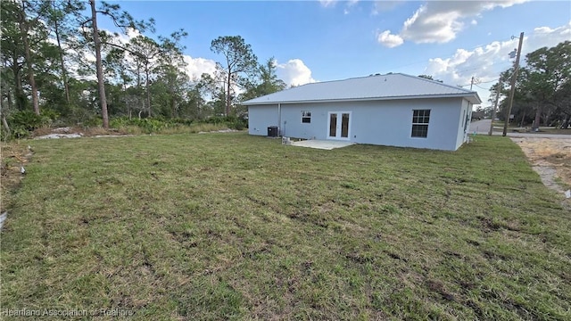 rear view of house with a yard, a patio area, and central air condition unit