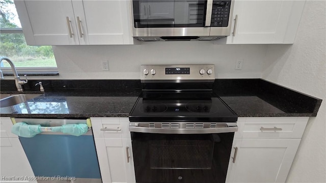 kitchen featuring white cabinetry, appliances with stainless steel finishes, sink, and dark stone countertops