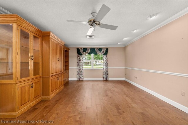 302 S Egret St, Sebring, FL 33870 - empty room featuring crown molding, light wood-type flooring, ceiling fan, baseboards, and a textured ceiling