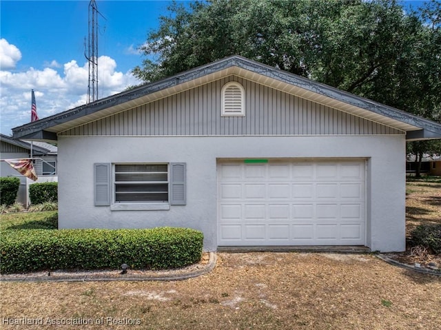 302 S Egret St, Sebring, FL 33870 - view of side of property with stucco siding, an attached garage, and an outdoor structure