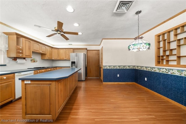302 S Egret St, Sebring, FL 33870 - kitchen featuring stainless steel fridge, dishwasher, dark countertops, wood finished floors, and ornamental molding
