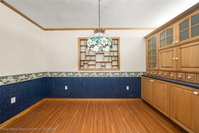 302 S Egret St, Sebring, FL 33870 - unfurnished dining area with wood finished floors, wainscoting, and crown molding