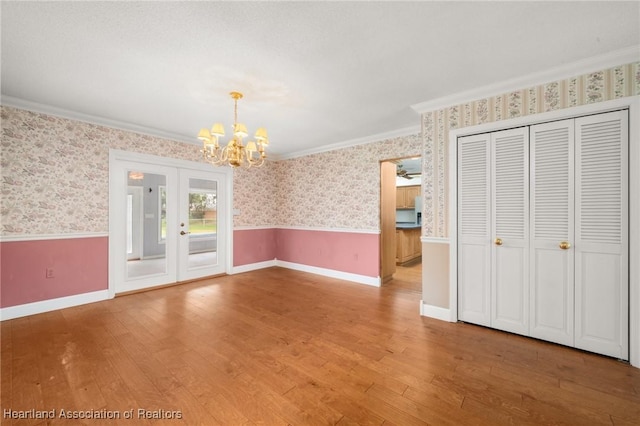 302 S Egret St, Sebring, FL 33870 - unfurnished dining area with wallpapered walls, light wood-style flooring, a chandelier, crown molding, and a wainscoted wall
