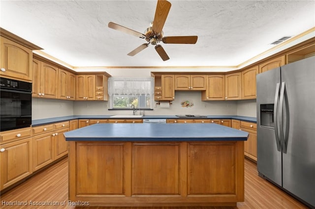 302 S Egret St, Sebring, FL 33870 - kitchen with black appliances, light wood-style flooring, a kitchen island, ceiling fan, and a textured ceiling